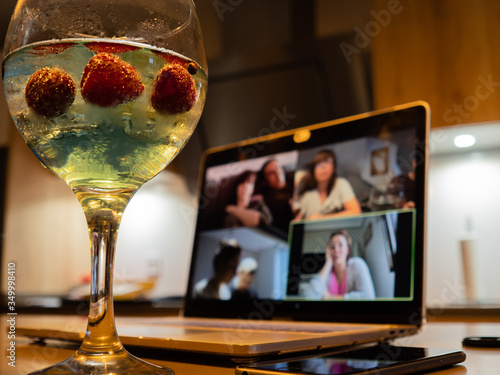 a gin and tonic with strawberries and blue tonic during a video call