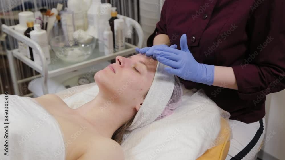 A professional beautician does facial massage to a woman. Cosmetology. A professional beautician does facial massage to a woman. Cosmetology.