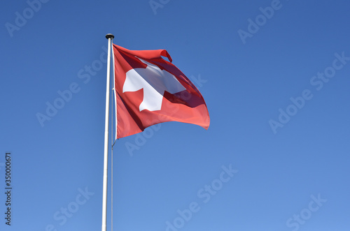 Swiss flag waving on blue sky