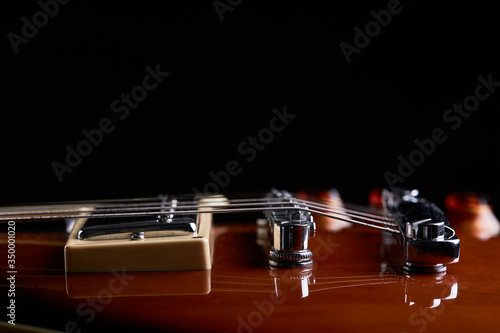 high contrast close up view for electric guitar. side view. music still life concept. bottom border.