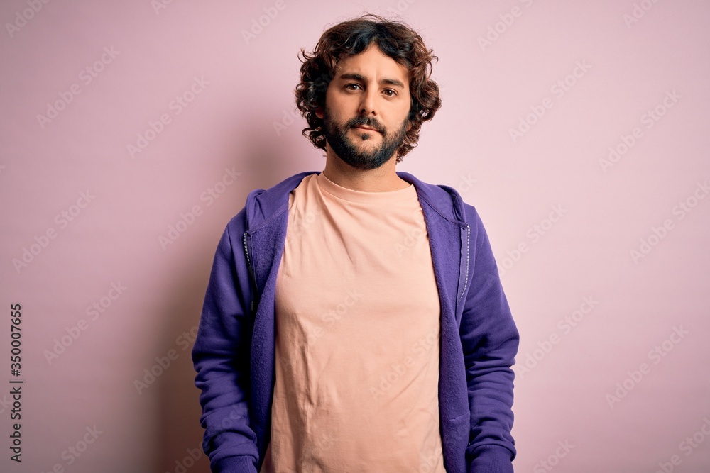 Fototapeta premium Young handsome sporty man with beard wearing casual sweatshirt over pink background looking sleepy and tired, exhausted for fatigue and hangover, lazy eyes in the morning.