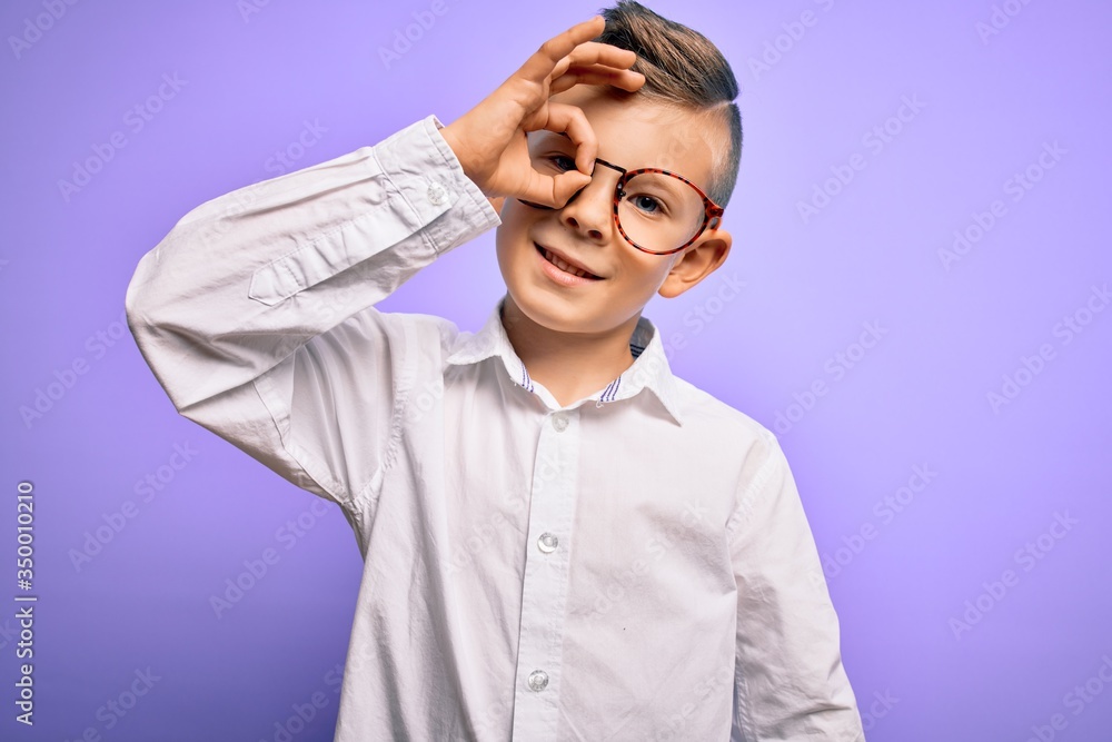 Young little caucasian kid with blue eyes wearing glasses and white shirt over purple background doing ok gesture with hand smiling, eye looking through fingers with happy face. Young little caucasian kid with blue eyes wearing glasses and white shirt over purple background doing ok gesture with hand smiling, eye looking through fingers with happy face.