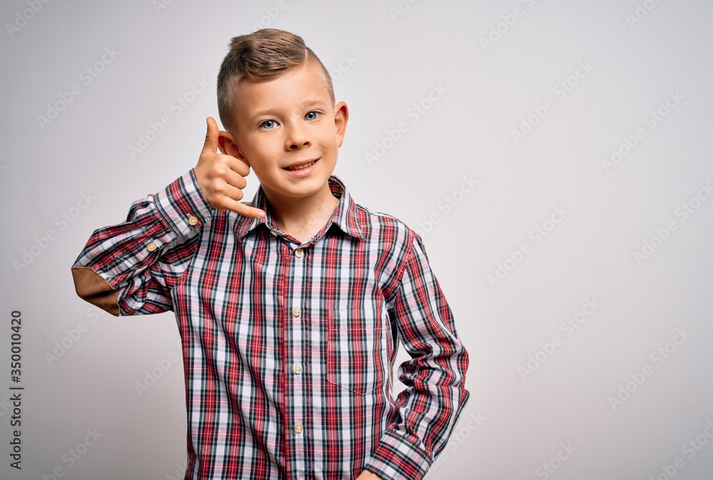 Young little caucasian kid with blue eyes wearing elegant shirt standing over isolated background smiling doing phone gesture with hand and fingers like talking on the telephone. Communicating Young little caucasian kid with blue eyes wearing elegant shirt standing over isolated background smiling doing phone gesture with hand and fingers like talking on the telephone. Communicating