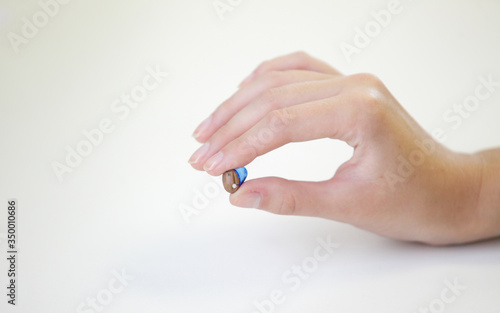 Very small hearing aid in a female hand