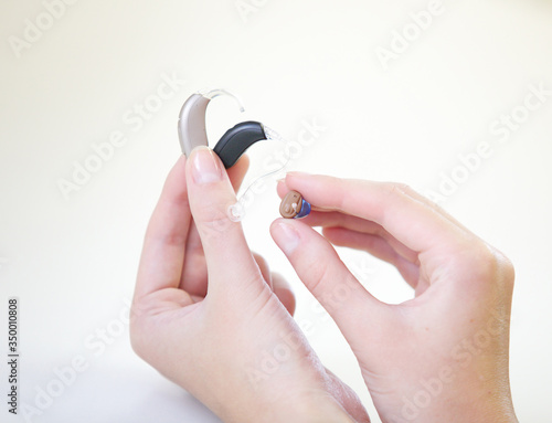 Three different hearing aids in female hands