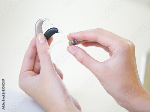 Three different hearing aids in female hands