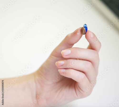Very small hearing aid in a female hand