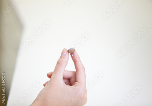 Very small hearing aid in a female hand