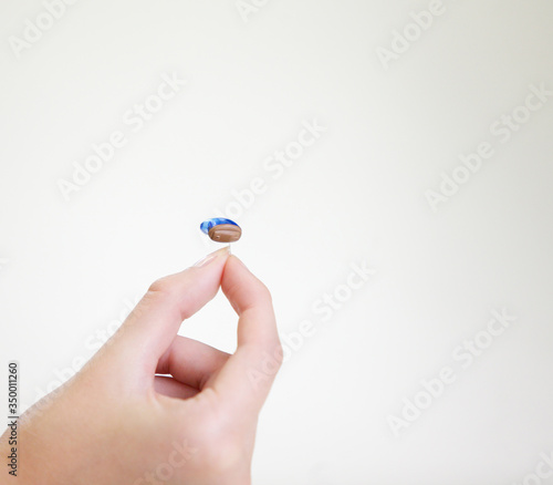 Very small hearing aid in a female hand