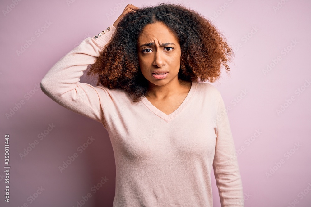 Young african american woman with afro hair wearing casual sweater over pink background confuse and wonder about question. Uncertain with doubt, thinking with hand on head. Pensive concept. Young african american woman with afro hair wearing casual sweater over pink background confuse and wonder about question. Uncertain with doubt, thinking with hand on head. Pensive concept.