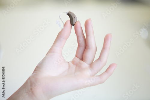 Very small hearing aid in a female hand