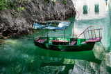Old rugged green boat docked in the small bay at Matka Canyon, Skopje, Macedonia