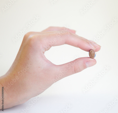 Very small hearing aid in a female hand