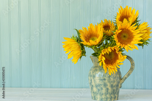 Foto Sunflowers. Summer bouquet in crockery with pastel background.