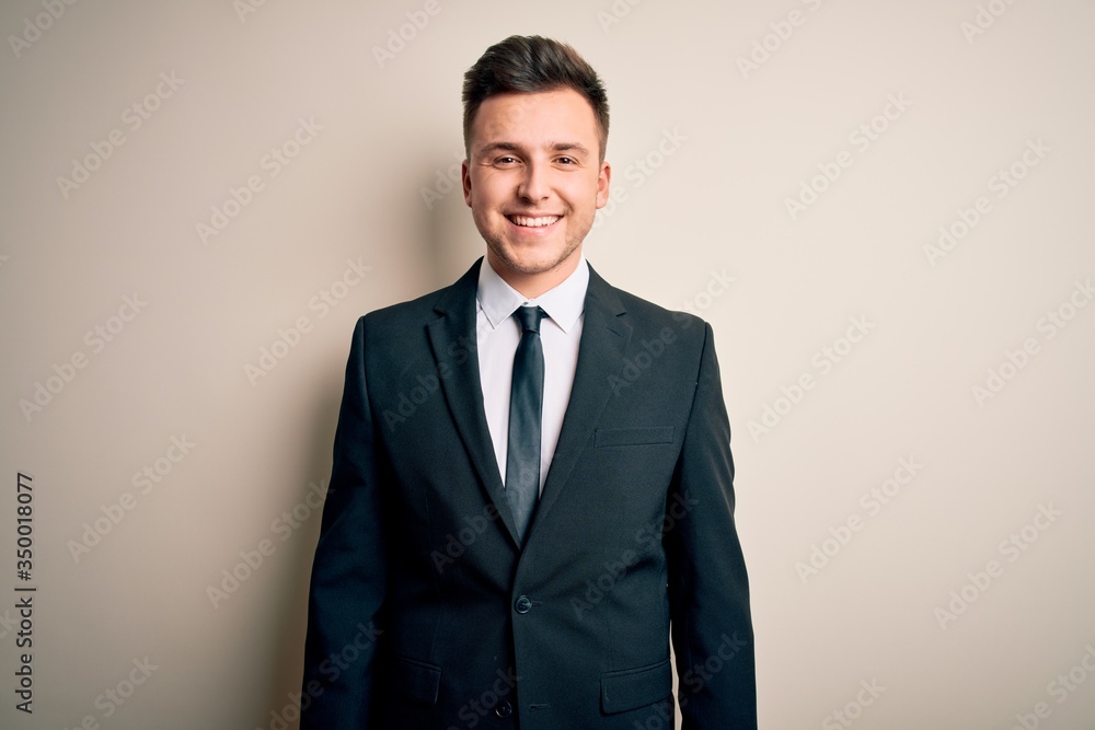 Young handsome business man wearing elegant suit and tie over isolated background with a happy and cool smile on face. Lucky person. Young handsome business man wearing elegant suit and tie over isolated background with a happy and cool smile on face. Lucky person.