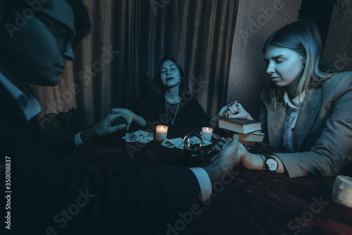 People hold hands of night at table with candles