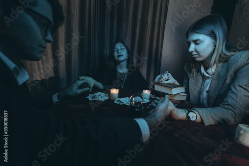 People hold hands of night at table with candles photo
