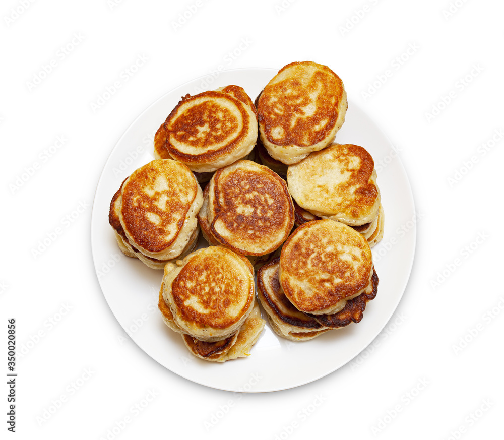 A pile of freshly baked pancakes lay on a plate isolated on white background.