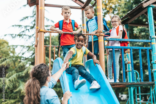 School children playing on the slide.