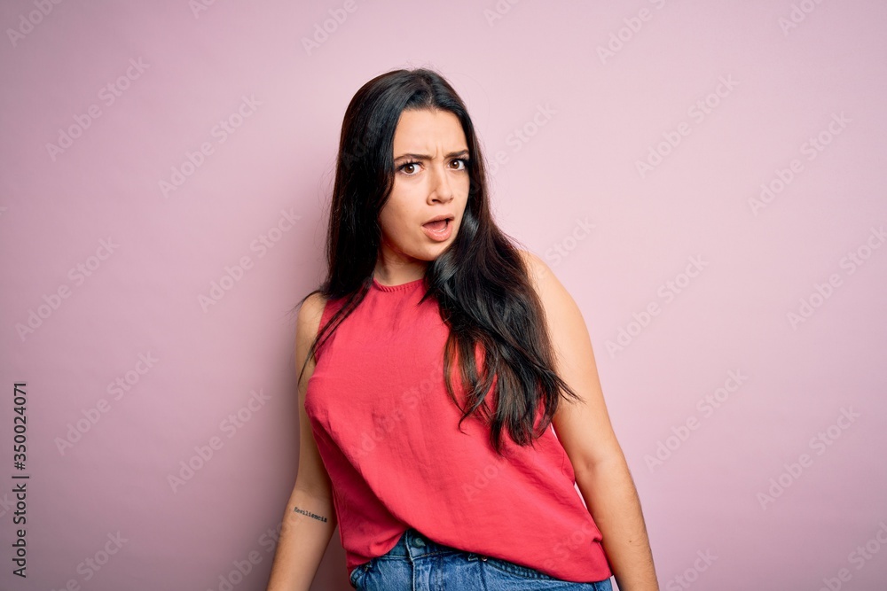 Obraz premium Young brunette woman wearing casual summer shirt over pink isolated background In shock face, looking skeptical and sarcastic, surprised with open mouth
