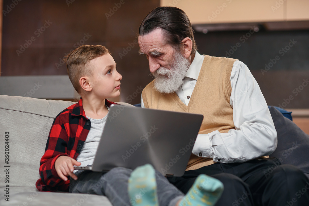 Grandson is teaching his grandfather to use laptop computer. Grandson is teaching his grandfather to use laptop computer.