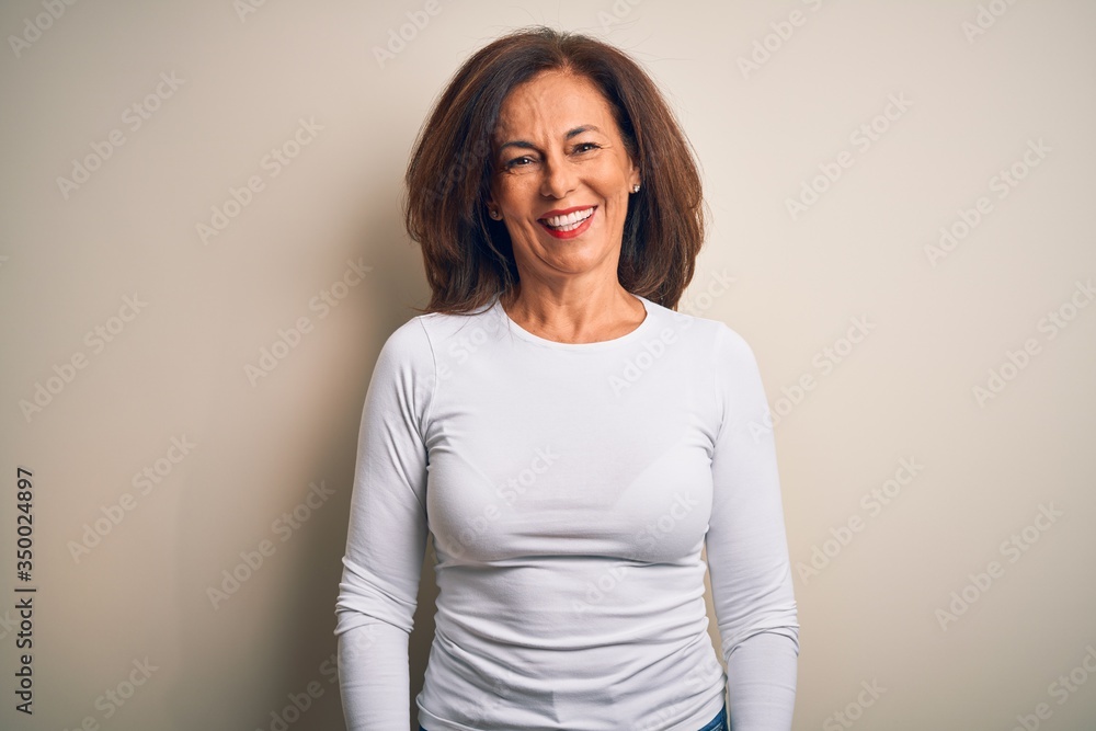 Middle age beautiful woman wearing casual t-shirt standing over isolated white background with a happy and cool smile on face. Lucky person. Middle age beautiful woman wearing casual t-shirt standing over isolated white background with a happy and cool smile on face. Lucky person.