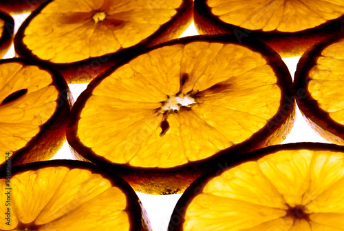 rebanadas de naranja a contra luz, vista de cerca, detalle naranja sobre fondo blanco