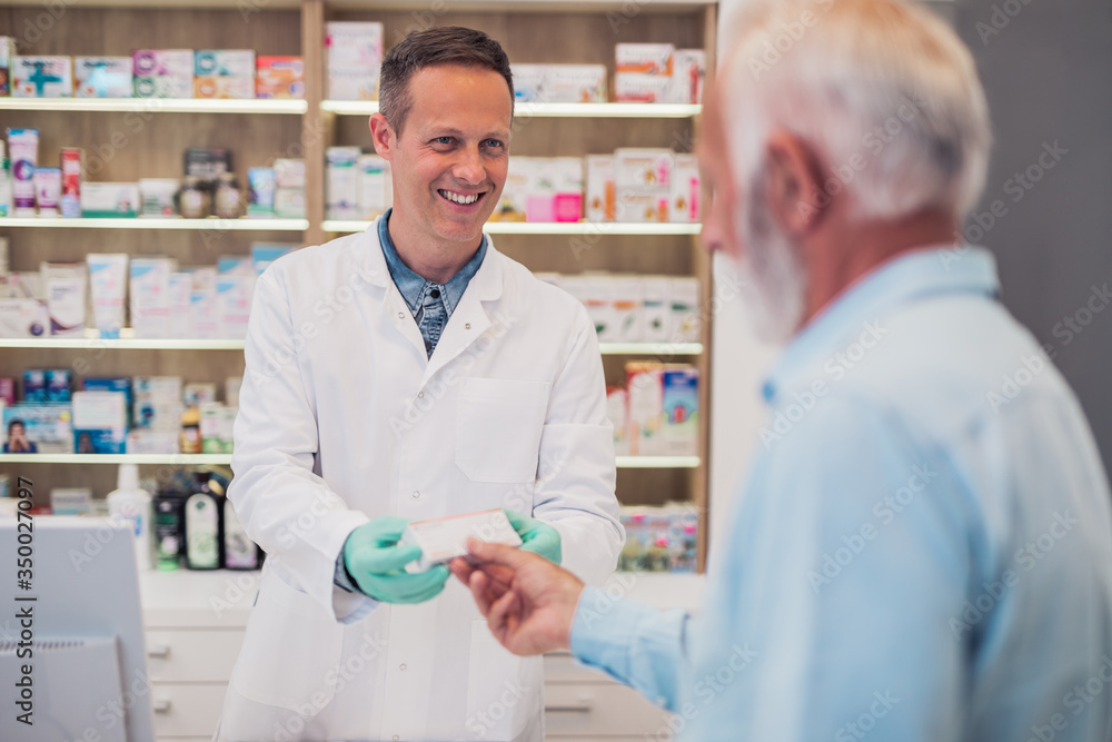 Professional pharmacist working with customer in modern drugstore.