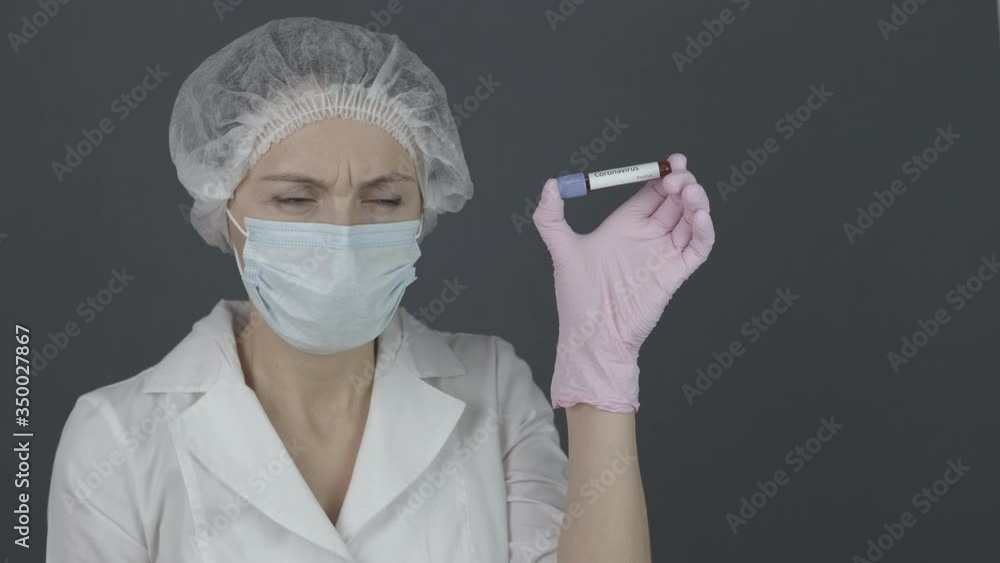 Man blood in tube. Woman laboratory assistant in shock from a test tube with blood with the inscription caronavirus. Man blood in tube. Woman laboratory assistant in shock from a test tube with blood with the inscription caronavirus.