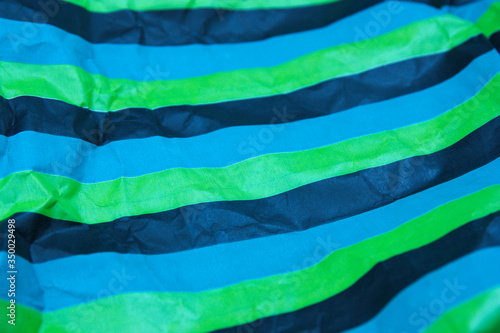 Image with horizontal stripes of the colors black, green, blue, on waste paper