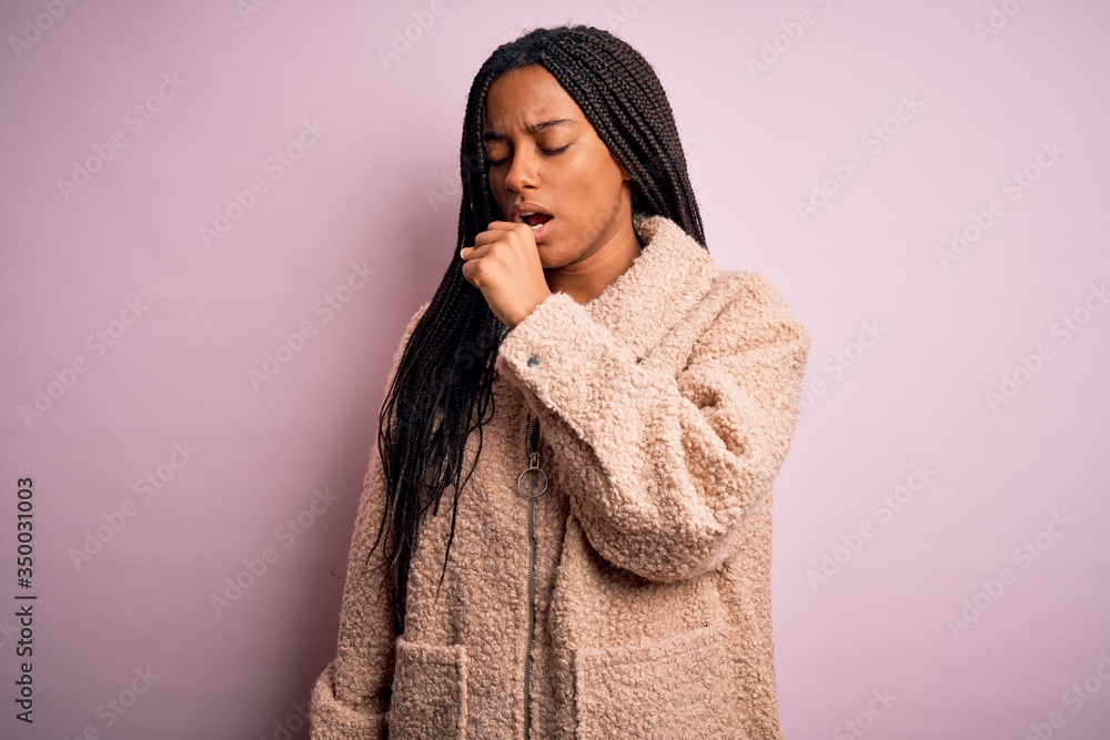 Young african american woman wearing fashion winter coat over pink isolated background feeling unwell and coughing as symptom for cold or bronchitis. Health care concept. Young african american woman wearing fashion winter coat over pink isolated background feeling unwell and coughing as symptom for cold or bronchitis. Health care concept.