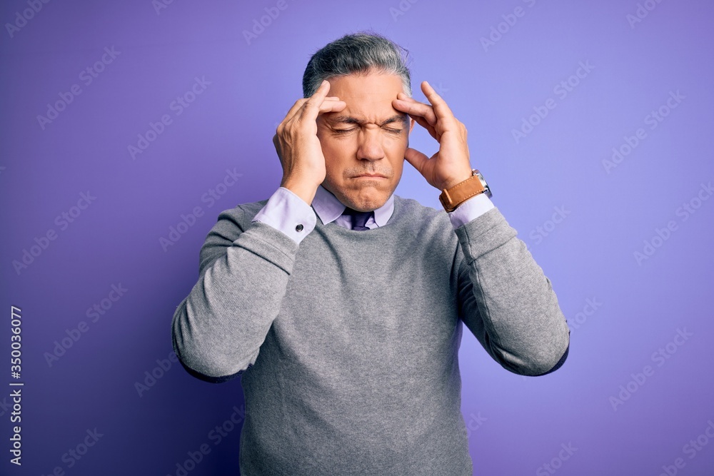 Middle age handsome grey-haired man wearing elegant sweater over purple background with hand on head for pain in head because stress. Suffering migraine. Middle age handsome grey-haired man wearing elegant sweater over purple background with hand on head for pain in head because stress. Suffering migraine.