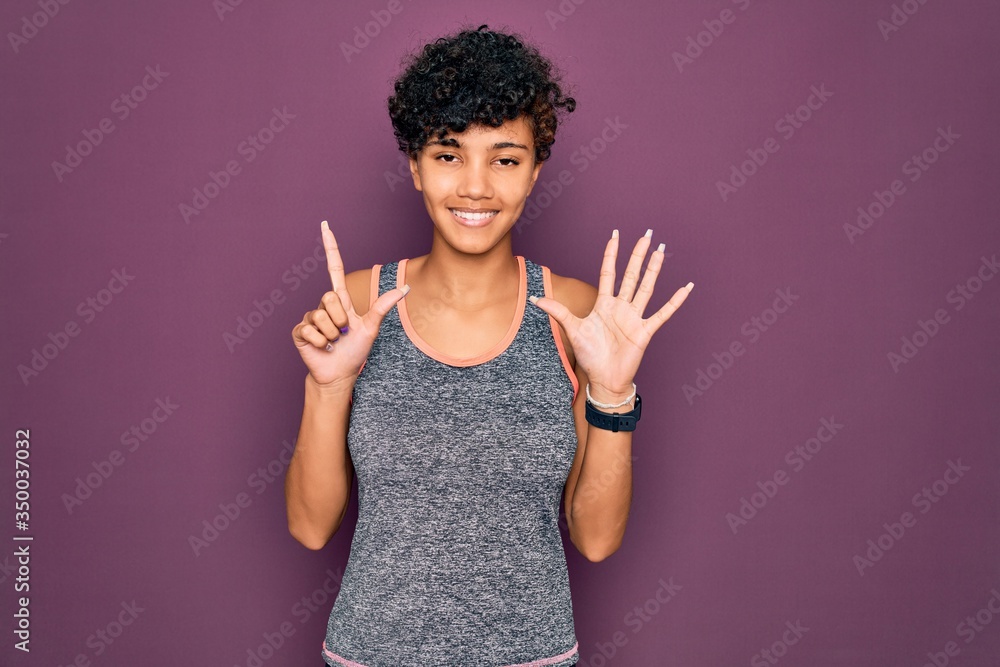 Young beautiful african american afro sportswoman doing exercise wearing sportswear showing and pointing up with fingers number seven while smiling confident and happy. Young beautiful african american afro sportswoman doing exercise wearing sportswear showing and pointing up with fingers number seven while smiling confident and happy.