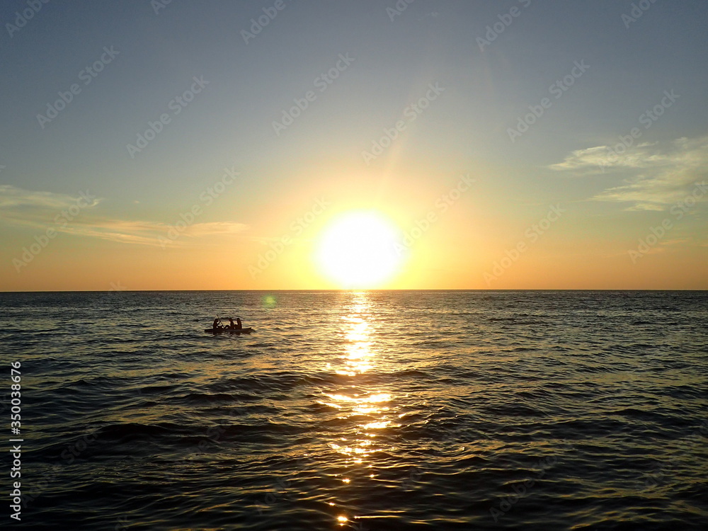 ボルネオの夕日の海を走るボート
