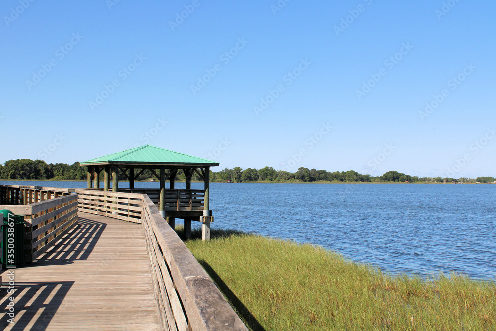 Wooden boardwalk during sunny summer with lake view