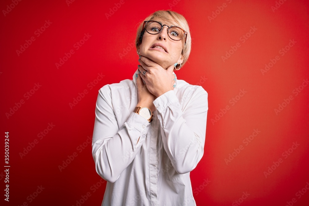 Young blonde business woman with short hair wearing glasses over red background shouting and suffocate because painful strangle. Health problem. Asphyxiate and suicide concept. Young blonde business woman with short hair wearing glasses over red background shouting and suffocate because painful strangle. Health problem. Asphyxiate and suicide concept.