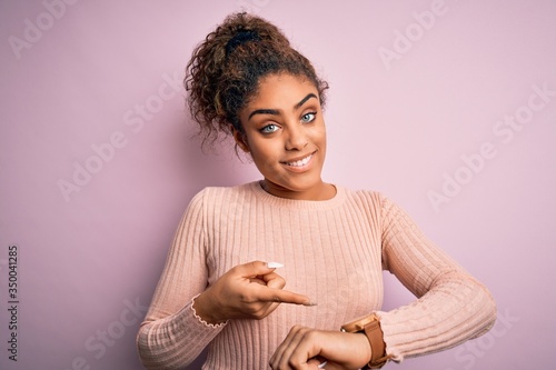 Schilderij op canvas Young beautiful african american girl wearing casual sweater standing over pink