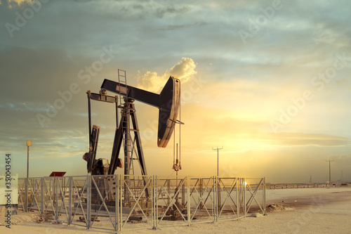 An oil pump jack with a beautiful sunset in the background
