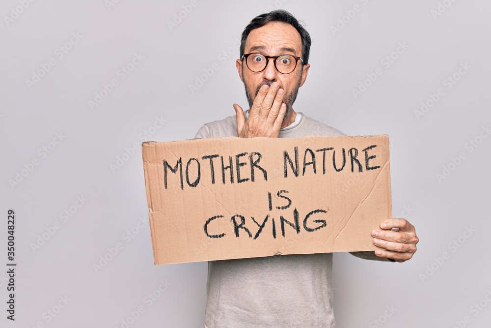 Middle age man asking for environment holding banner with mother nature is crying message covering mouth with hand, shocked and afraid for mistake. Surprised expression Middle age man asking for environment holding banner with mother nature is crying message covering mouth with hand, shocked and afraid for mistake. Surprised expression