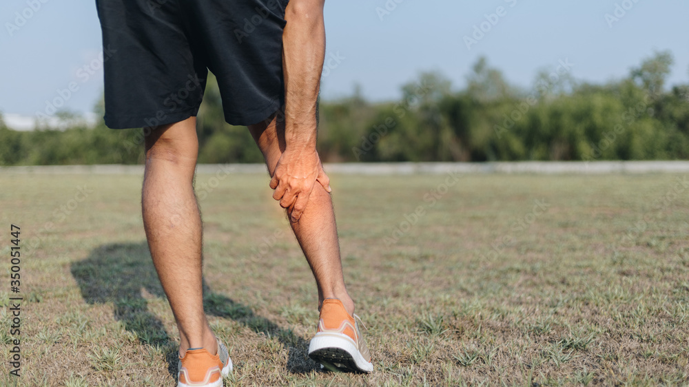 Sports man holding pain in the calf, after running and exercise