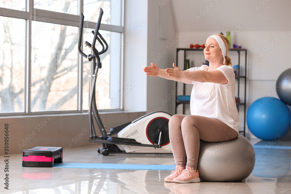 Woman with excess weight training in gym Woman with excess weight training in gym