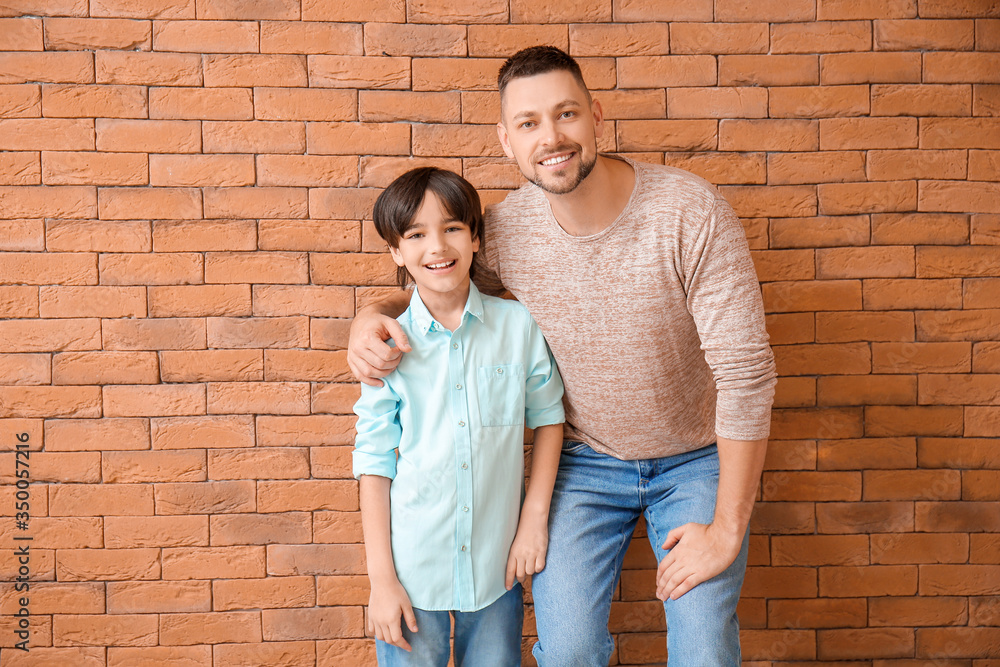 Father and little son on brick background Father and little son on brick background