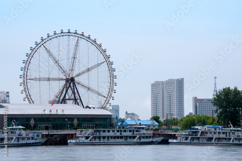 China  Heihe  July 2019  River station and Ferris wheel on the banks of the Amur river near the city of Heihe in summer