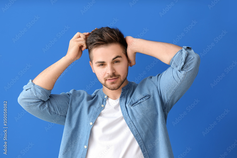 Handsome man with stylish hairdo and comb on color background Handsome man with stylish hairdo and comb on color background