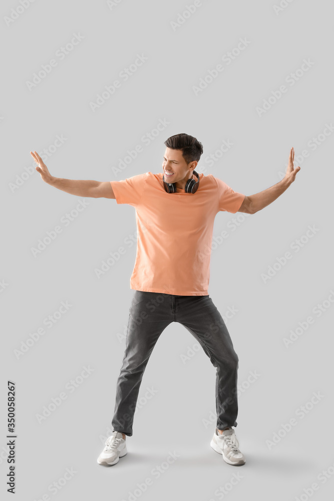 Handsome young man dancing against light background Handsome young man dancing against light background