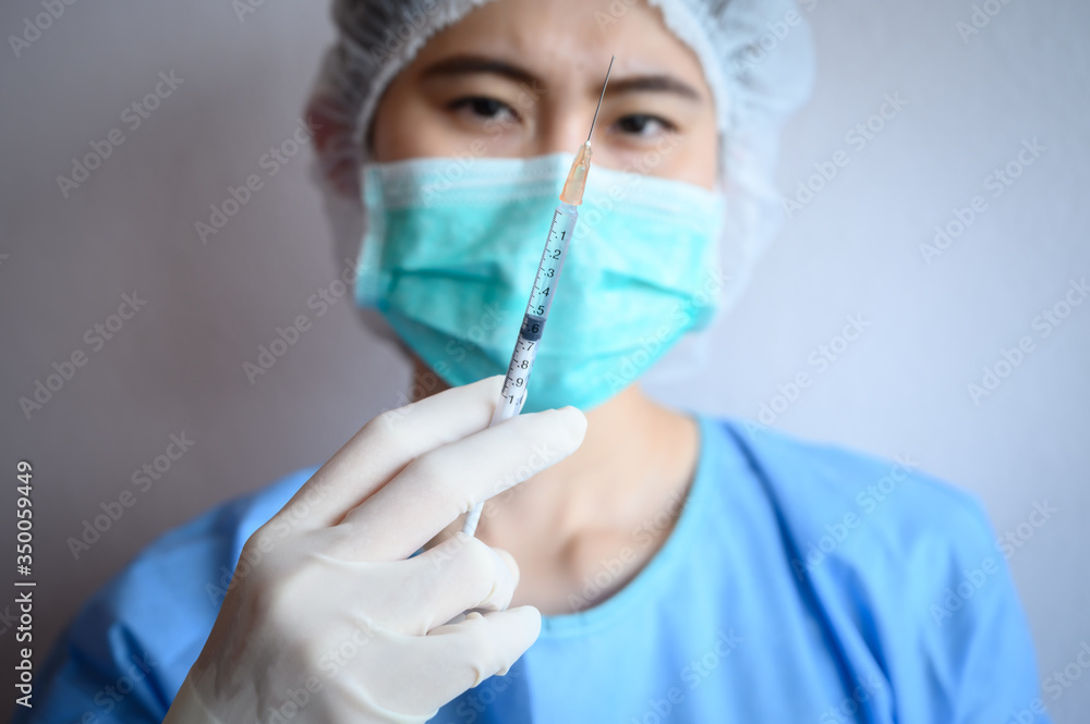Healthcare worker holding a syringe before injection vaccine or medicine to patients. Syringes are frequently used in clinical medicine to administer injection into the bloodstream. Healthcare worker holding a syringe before injection vaccine or medicine to patients. Syringes are frequently used in clinical medicine to administer injection into the bloodstream.
