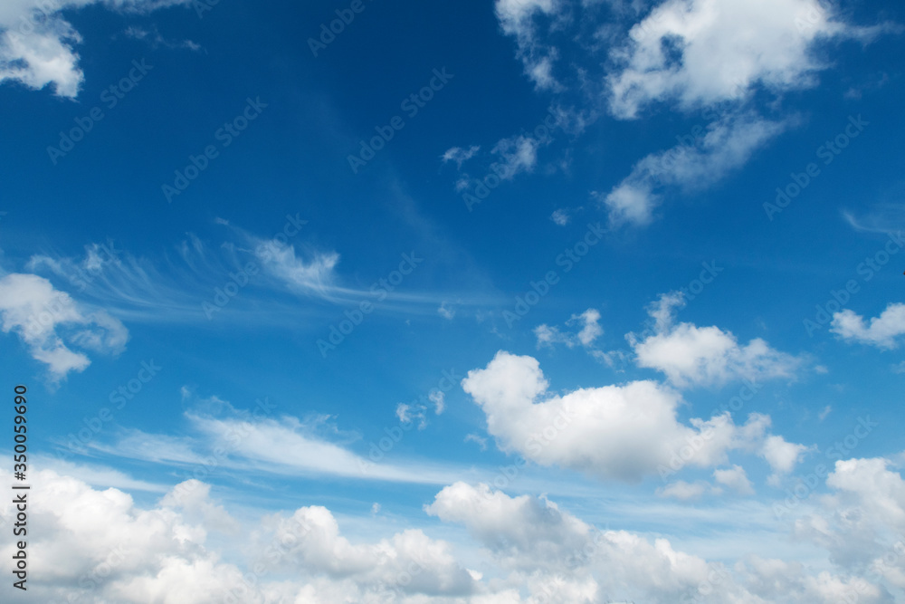 Beautiful sunny blue sky background with cotton candy & puffy fluffy white cumulus clouds on bright daylight horizon in tropical summer or spring sunlight & sun rays at sunshine day, copy free space Beautiful sunny blue sky background with cotton candy & puffy fluffy white cumulus clouds on bright daylight horizon in tropical summer or spring sunlight & sun rays at sunshine day, copy free space