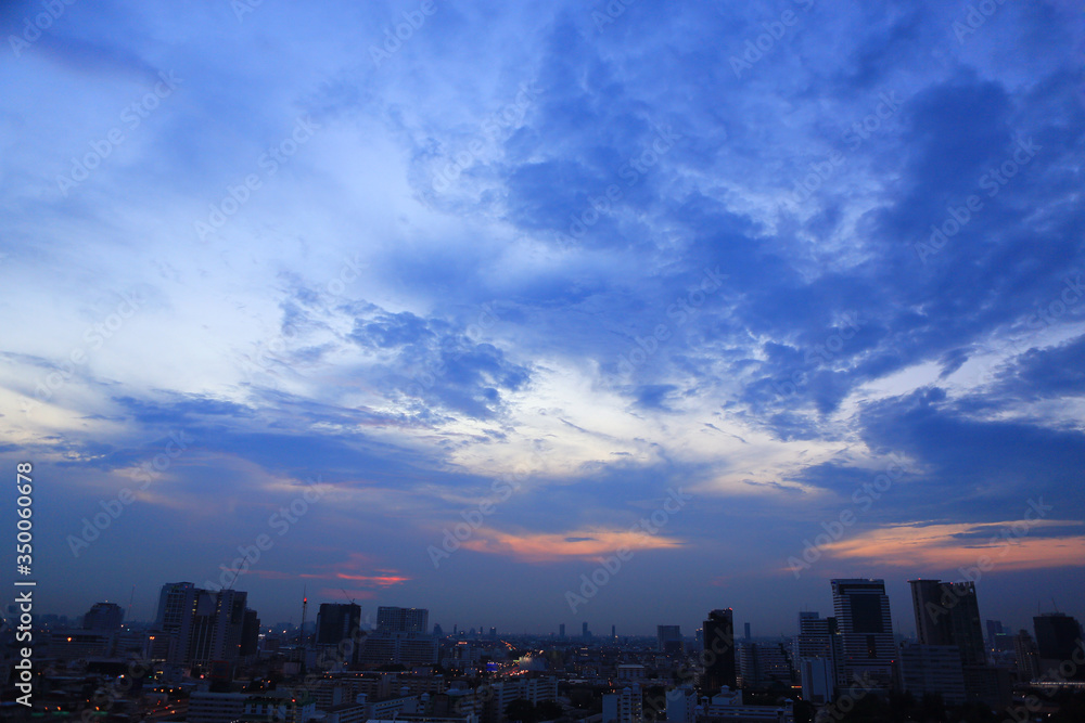 Abstract blue-orange clouds at sunset sky and building of bangkok city background. Panorama style