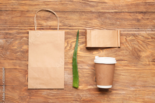 Paper bags with cup on wooden background