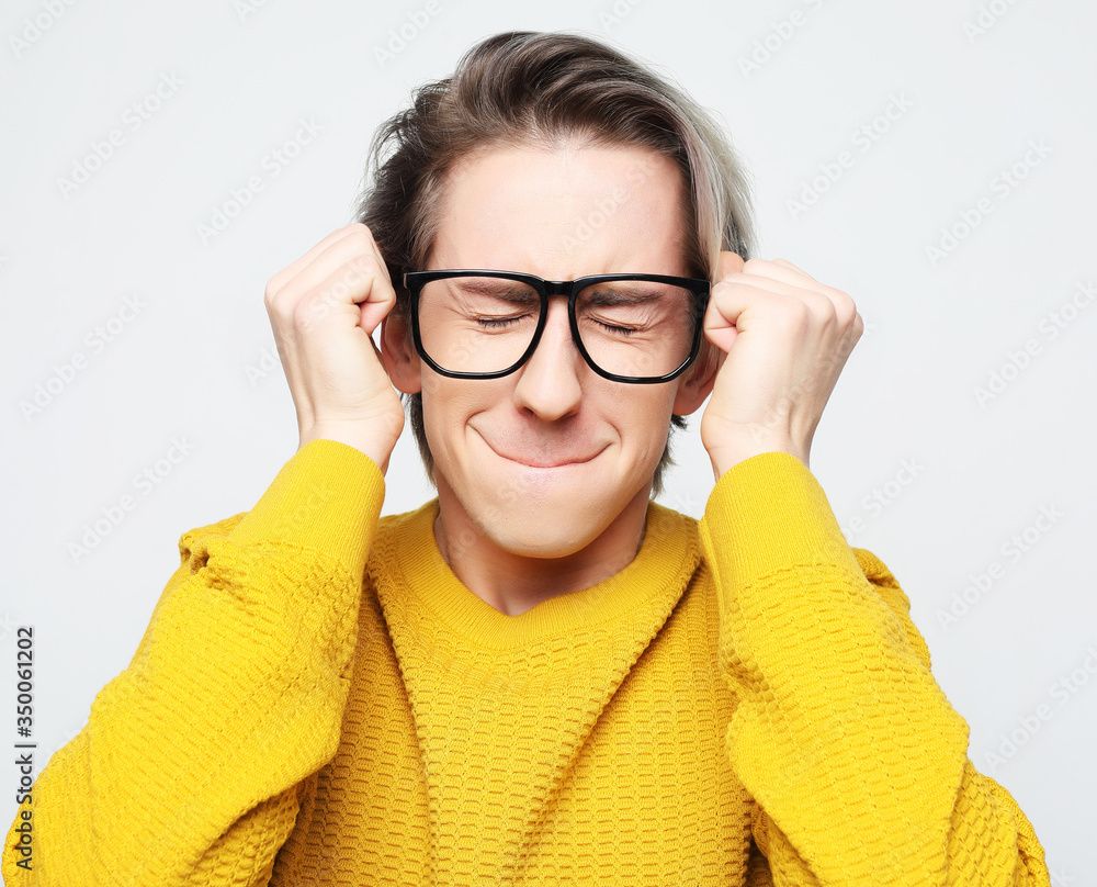 Waiting for special moment. Portrait of young man wearing yellow sweater and glasses